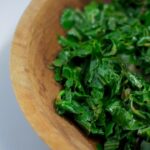 Sauteed greens with garlic in wooden bowl