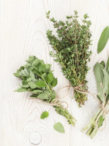 Fresh garden herbs on wooden table. Oregano, thyme, sage. Top view