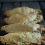 Chicken and vegetable handpies on wooden background