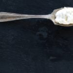 homemade cream cheese on silver spoon on dark background