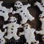 Shortbread cookies shaped like gingerbread men with white glaze and decorated by dried currants