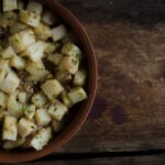 Roasted potatoes with liver in a terra cotta bowl on wooden background