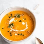 red curry squash soup garnished with mustard seeds and thyme