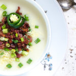 loaded baked potato soup garnished with bacon, sliced jalapenos and sliced scallions