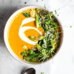 red kuri squash soup garnished with herbs