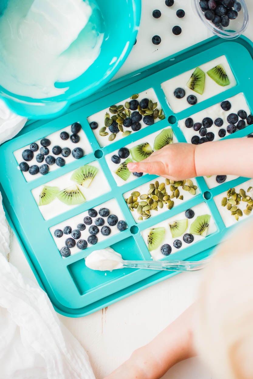 Putting berries and kiwi into frozen yogurt bars.