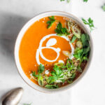 tomato and bean soup garnished with herbs and almonds