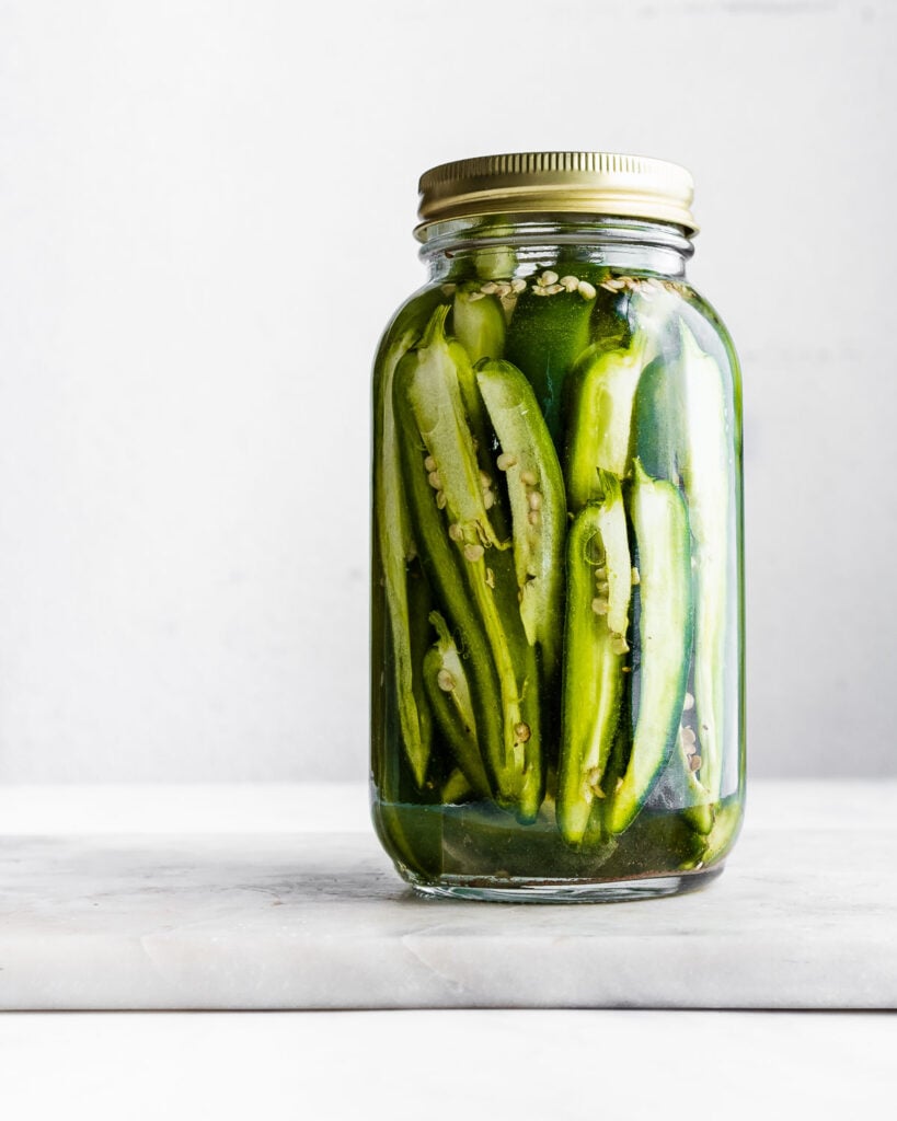 Fermented jalapeno spears in a mason jar.