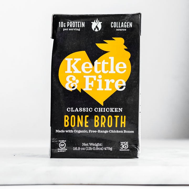 Box of kettle and fire bone broth on plain background