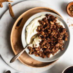 dark chocolate granola in an earthenware bowl garnished with fresh whole milk yogurt