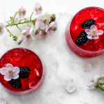 Blackberry switchel garnished with blackberries and blackberry flowers