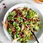 Brussels Sprout Slaw in White Bowl Garnished with Pomegranates