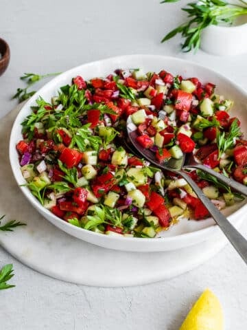 Tomato cucumber salad in white bowl