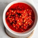 Fermented chili mash in a white bowl on a marble surface