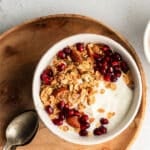 Filmjolk yogurt in a white bowl served with pomegranate seeds and granola