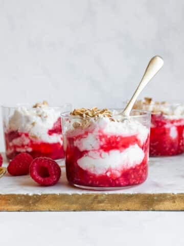 Cranachan in a small glass, garnished with fresh raspberries