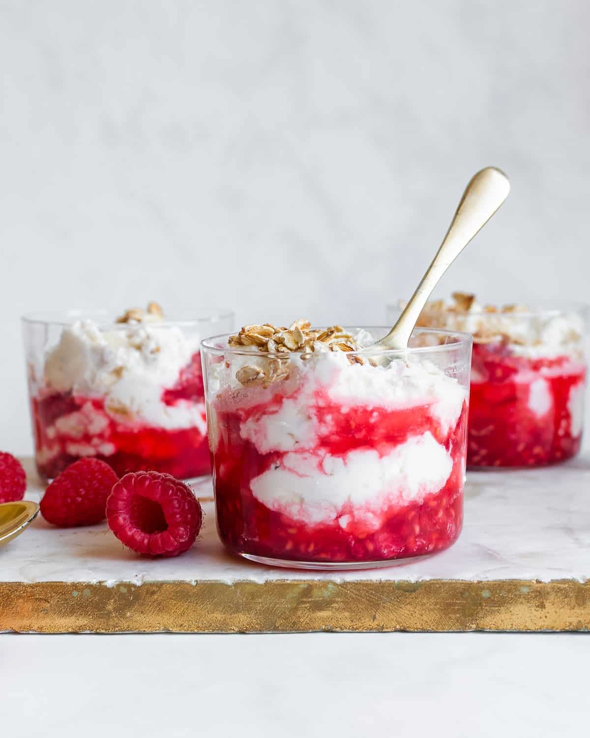 Cranachan in a small glass, garnished with oats and raspberries
