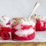 Cranachan in a small glass, garnished with fresh raspberries